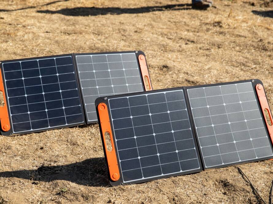 a couple of black and orange rectangular objects on a dirt surface
